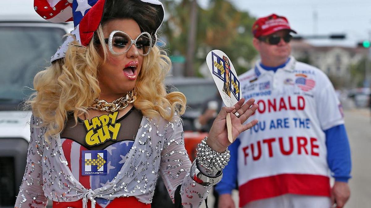 Algunos de los seguidores de Clinton y más atrás un seguidor de Donald Trump afuera del recinto Wilton Manors donde se encuentra la candidata demócrata Hillary Clinton, el 30 de octubre de 2016.