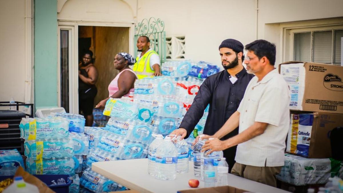 Immam Sultan y Sohail Kothari ayudan a distribuir agua a residentes de Liberty City afectados por el huracán Irma en la mezquita Masjid Al-Ansar en Miami.