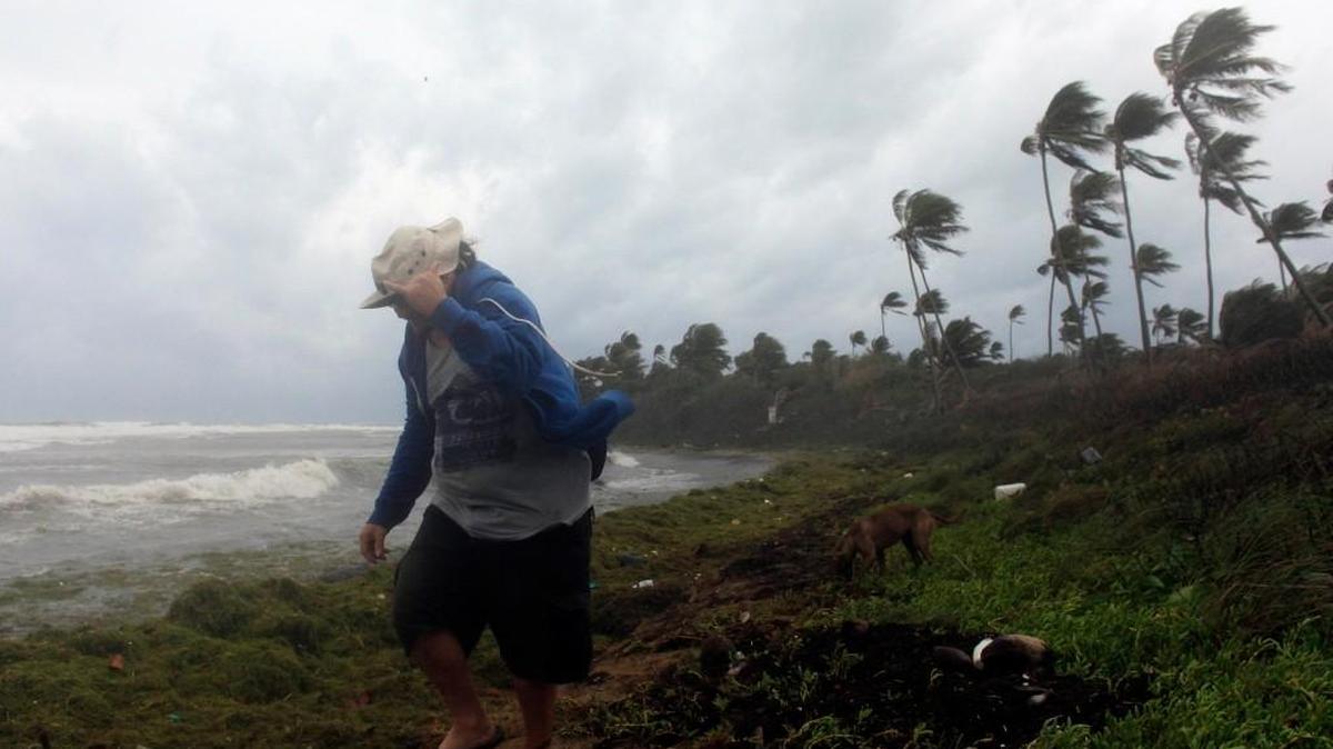 
Un hombre camina por la costa en medio de la tormenta en Guayama, Puerto Rico. A su paso por el Caribe, Erika produjo numerosos estragos.
