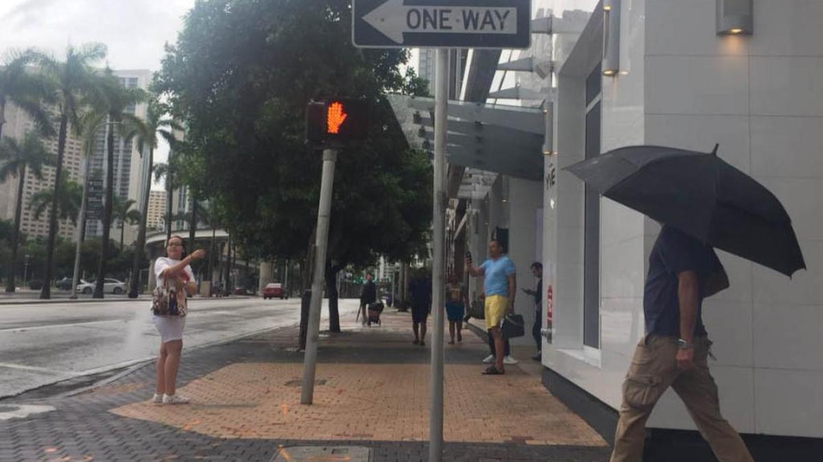 Unos turistas se toman una foto para luego regresar a un restaurante en Biscayne Boulevard, el jueves cerca de downtown Miami.