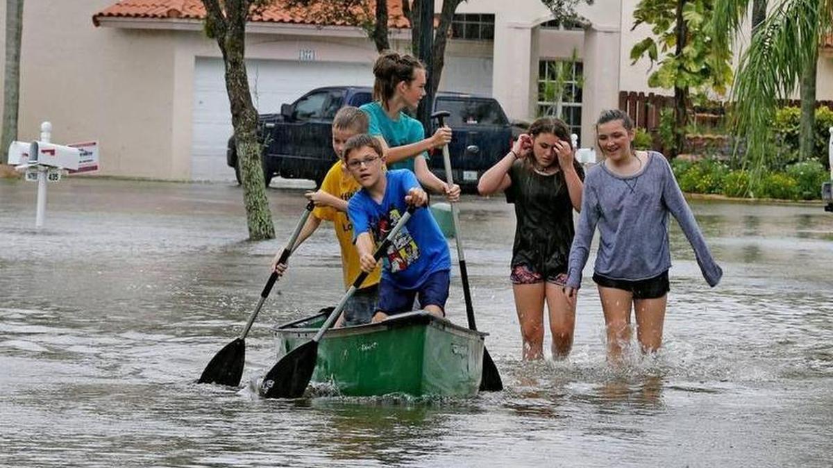 William Potash, de 10 años, se reúne con sus amigos en el barrio de Vista Filare, en el oeste de Davie, usando una canoa para navegar por las calles, el 7 de junio de 2017.