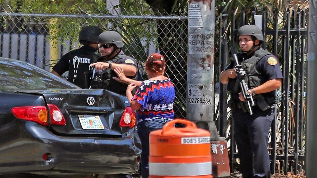 Agentes de policía de Miami detienen a una mujer para inspeccionar la maletera de su auto, el viernes 12 de mayo de 2017 en la Calle Flager y la avenida 29. La policía estaba buscando a un joven sospechoso de robarse un auto.