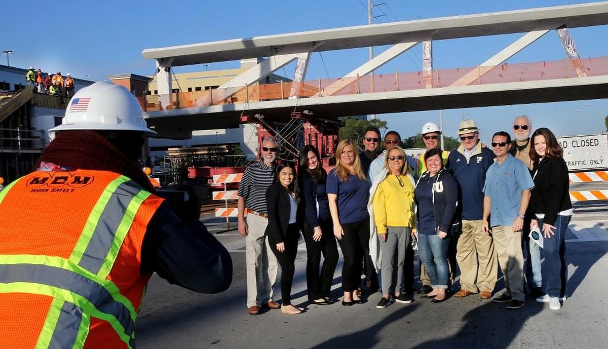 El presidente de FIU, Mark Rosenberg (cuarto desde la derecha), posa para una foto junto a miembros del equipo de construcción del puente el día que fue colocado en su lugar.