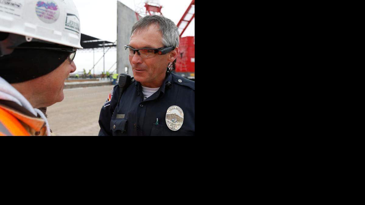 
Un oficial de policía habla con un trabajador de la construcción en West Valley City, Utah, mientras lleva una cámara portátil en sus lentes. 


