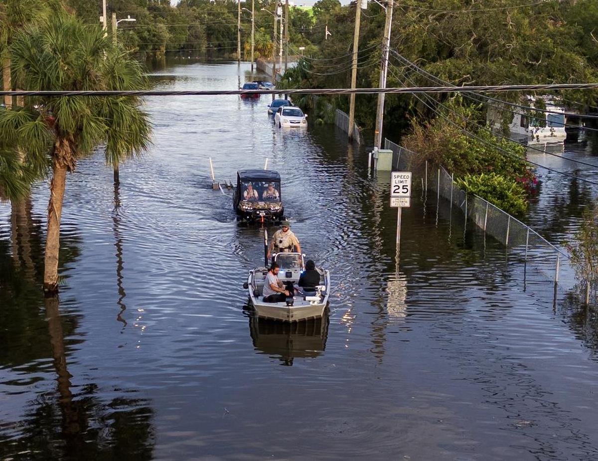 Florida Fish and Wildlife Conservation Commission officers ride on a flats boat through the flooded N 12th St in North Tampa, on Thursday, October 10, 2024, a day after Hurricane Milton crossed Florida’s Gulf Coast.
