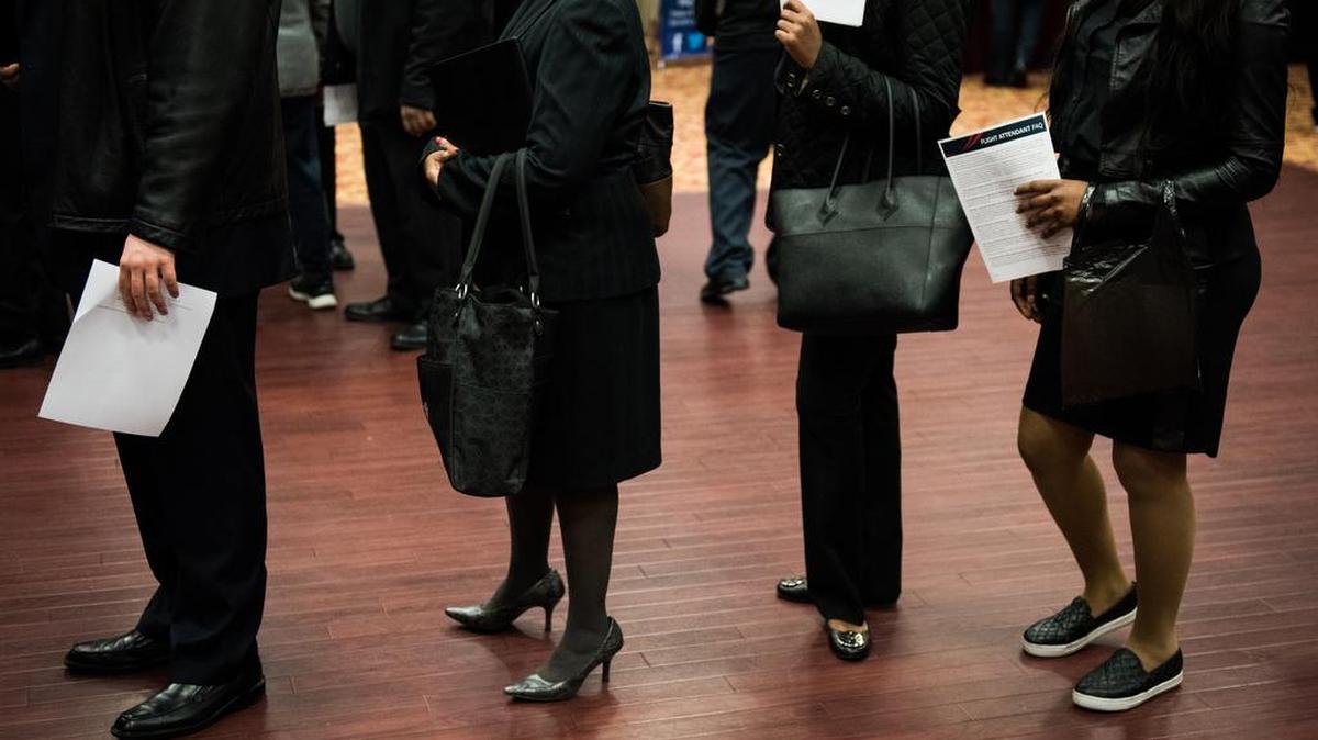 Personas que buscan trabajo esperan en línea en una feria laborale en Nueva York el 10 de noviembre de 2016.