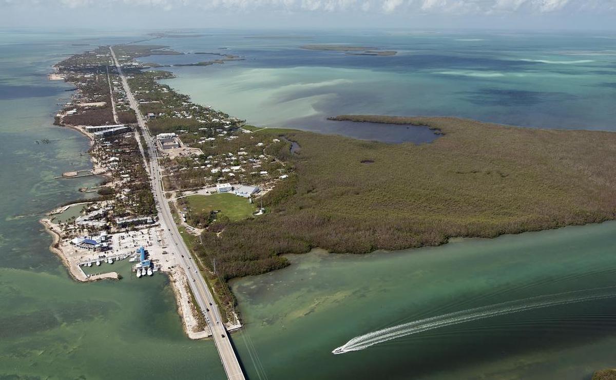 Foto aérea proporcionada por la Oficina de Noticias de Florida Keys, una pequeña embarcación se acerca al puente Whale Harbour el domingo 1 de octubre de 2017 en Islamorada, Florida.