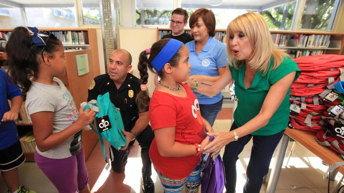 El jefe de la Policia de Miami, Fernando Fernández, izquierda, Alicia Fernández, asistente del comisionado Francis Suarez, y la comisionada de la Junta Escolar, Mary Tere Rojas en la entrega de mochilas y útiles escolares.