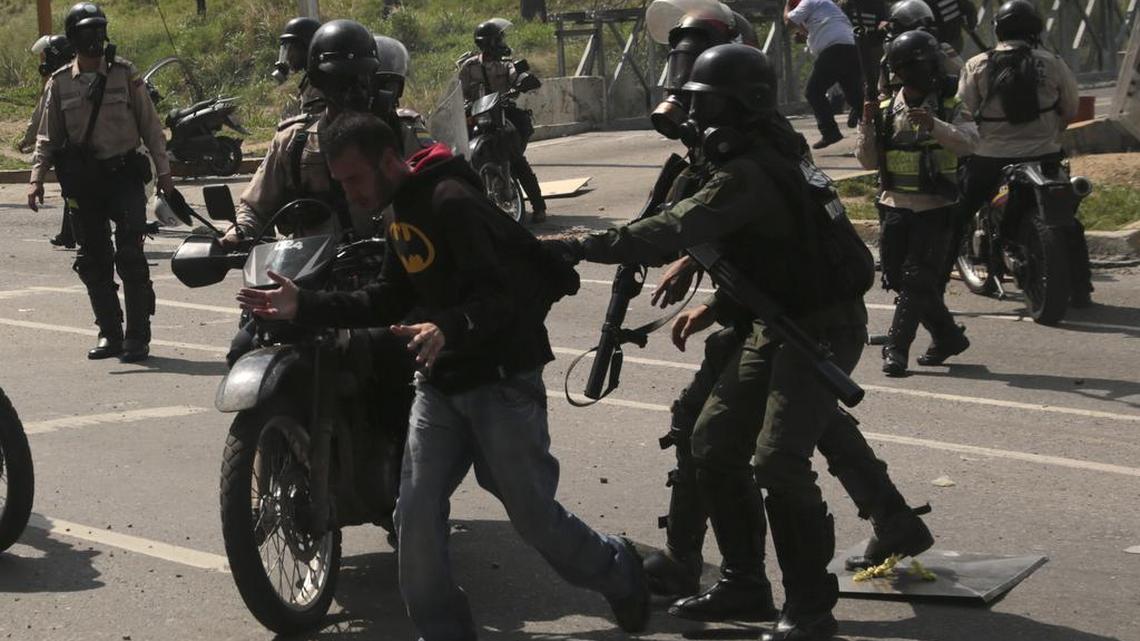 Integrantes de la Guardia Nacional Bolivariana detienen a un manifestante durante una marcha hacia el Tribunal Supremo de Justicia de Venezuela, en Caracas el 10 de mayo.