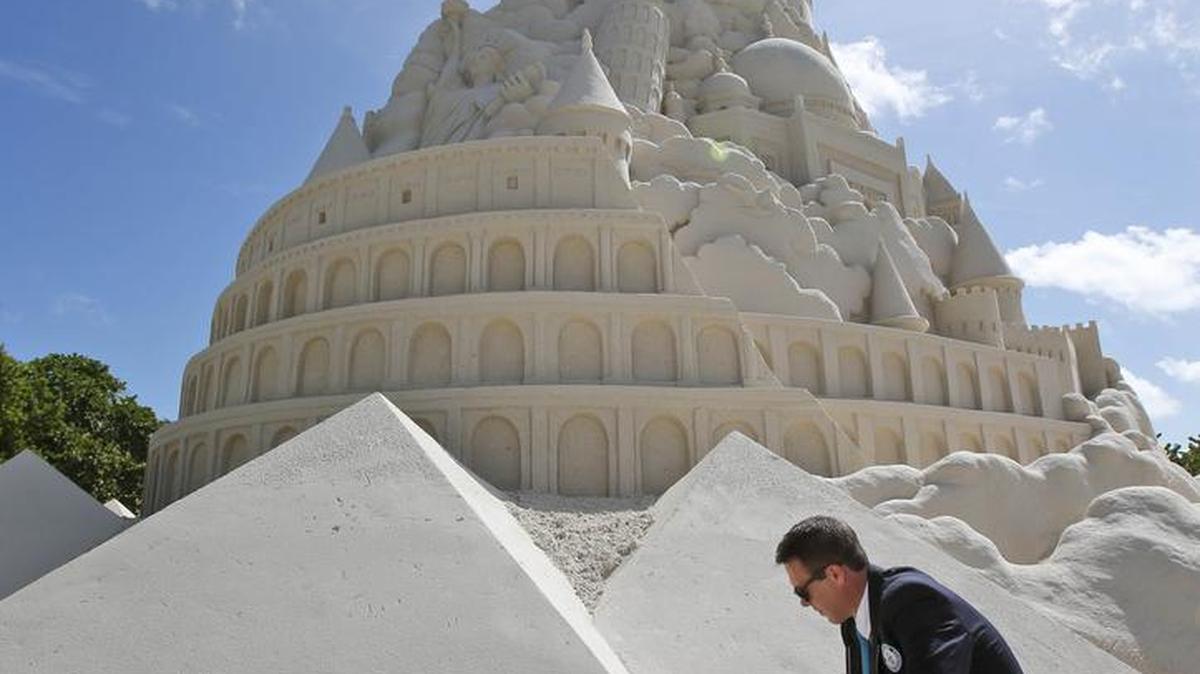 El adjudicador de los récord Guinness, Philip Robertson ve sobre la arena utilizada en un intento de récord para construir el castillo de arena más alta, este lunes, 26 de octubre 2015, en Virginia Key Beach en Miami.