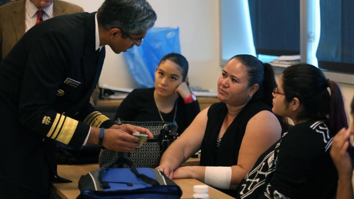 El cirujano general de Estados Unidos, Vivek H. Murthy, habla con Blanca Irahera, centro, en el Centro Medico Borinquen.