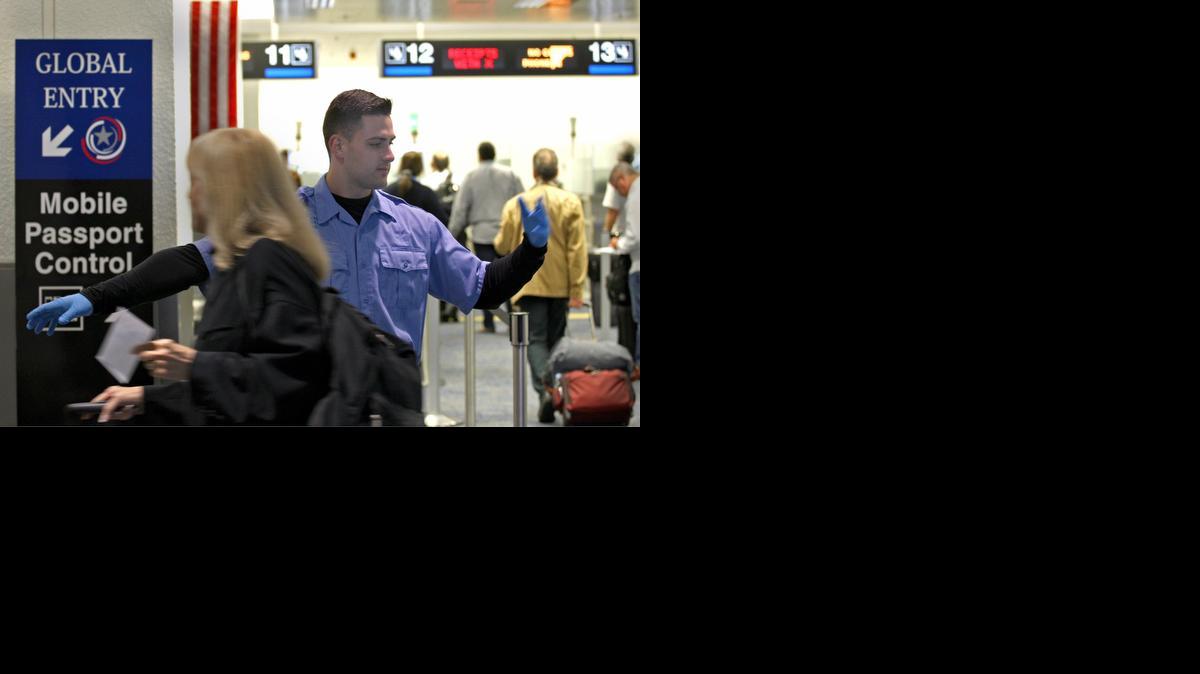 
Carlos Martínez (cent.), especialista de operaciones generales del MIA, guía a los viajeros que arriban al aeropuerto hacia los nuevos controles de pasaportes que usan aplicaciones de telefonía celular.


