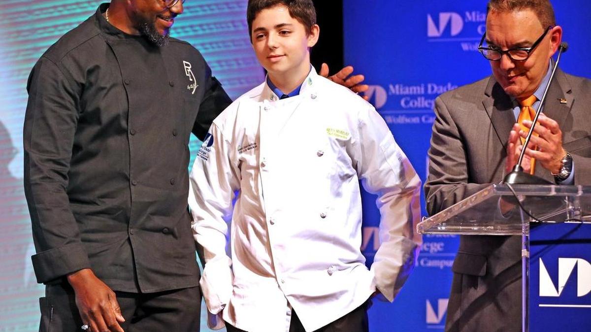 Chef Richard  Ingraham (izq.) con Seth Munday durante la entrega de uniformes en el Instituto Culinario de MDC.