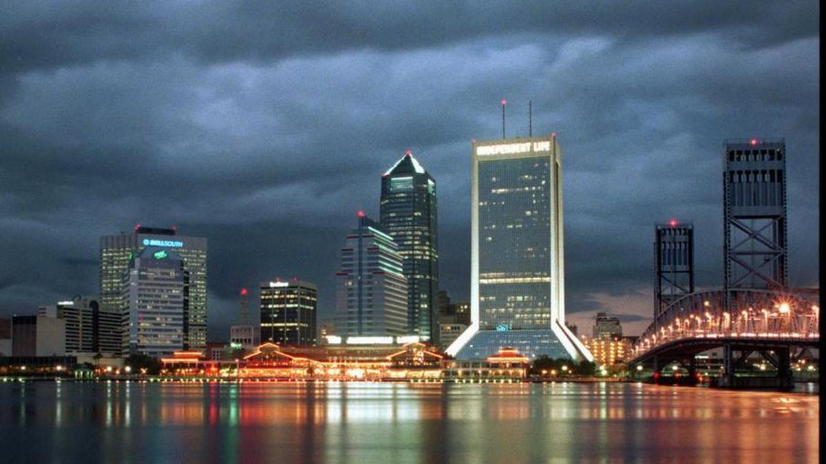Summer storm clouds hover over Downtown Jacksonville and the St. Johns River at dusk.