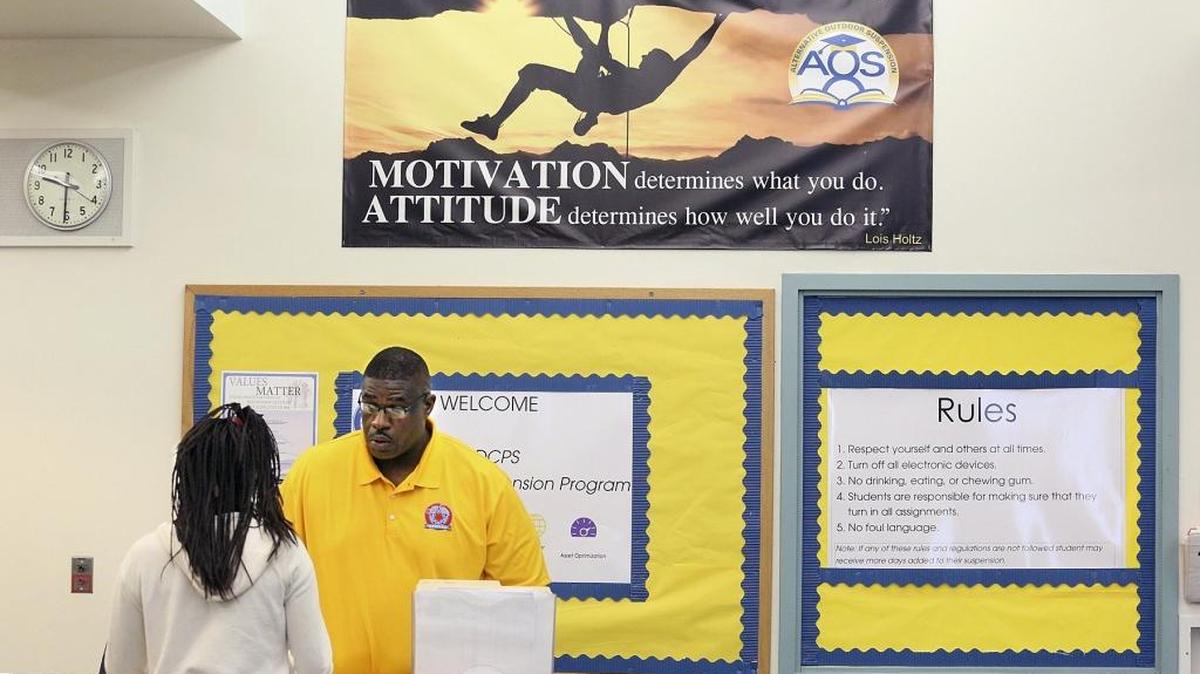 Maxie Graham, un coordinador del Success Center en Miami, revisa la tarea de un estudiante al comienzo del año escolar.