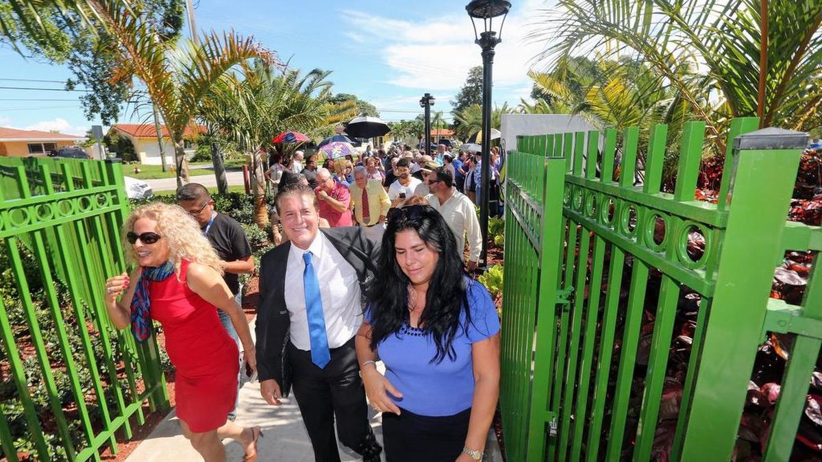 
El alcalde de Hialeah Carlos Hernández entra seguido de un grupo de visitantes al recien abierto “Jardín de las Artes” el viernes.
