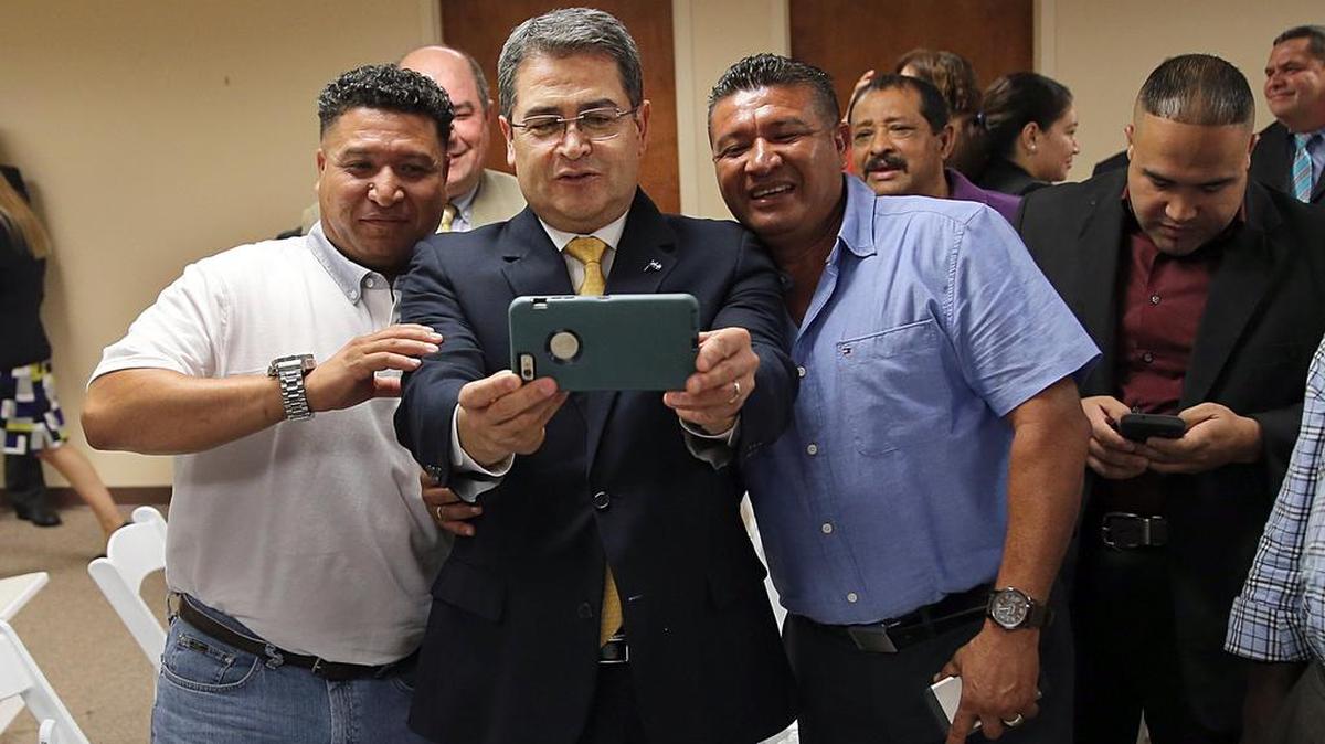 El presidente de Honduras, Juan Orlando Hernández, se toma un ‘selfie’ el miércoles en Miami con los líderes comunitarios hondureños, Héctor (izq.) y Marcos Ayala (der.), tras sostener una reunión sobre el TPS.