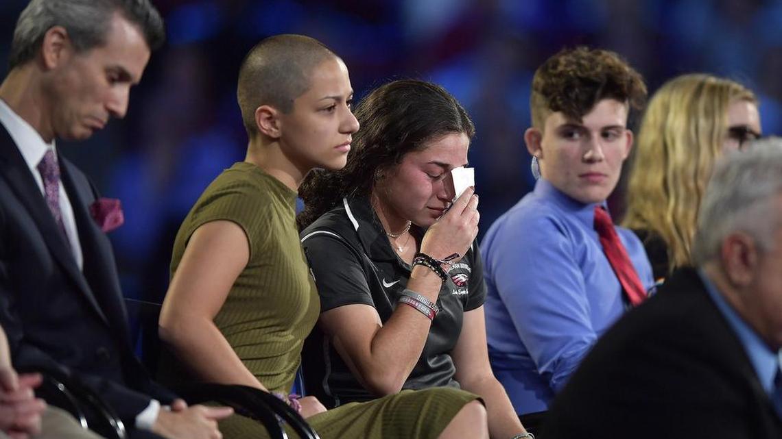 Emma González (vestida de verde), alumna de la secundaria Marjory Stoneman Douglas, conforta a una compañera de escuela durante el debate organizado por CNN el 21 de febrero en Sunrise, Florida.