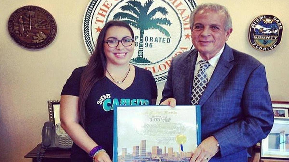 JennyLee Molina junto al alcalde de Miami, Tomás Regalado, posan con la proclama de convertir las 3:05 p.m. como la hora oficial del café de la ciudad. La proclama fue hecha en 2013.