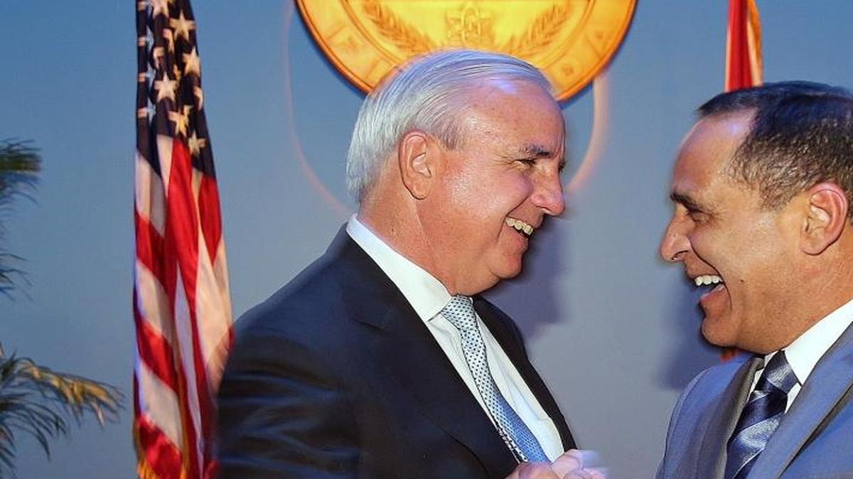 El alcalde de Miami-Dade, Carlos Giménez (izq), estrecha el martes la mano del comisionado Joe Martínez tras la ceremonia de juramentación.
