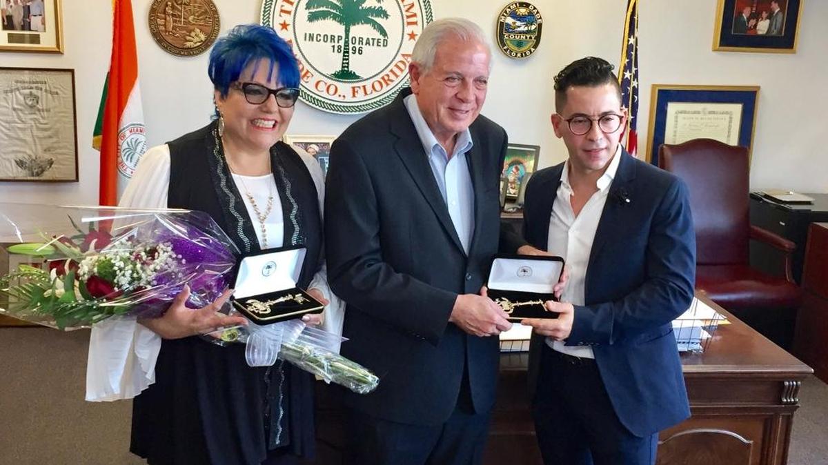 Malena Burke (izq.) y Flavio Díaz Vilela (der.) exhiben las llaves de la ciudad que les fueron otorgadas el viernes por el alcalde de Miami, Tomás Regalado.