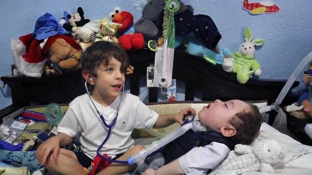 Adrián Quesada, de 5 años, juega a los médicos con su hermano mellizo, Alejandro, que sufre de numerosos problemas médicos, en una imagen del 21 de diciembre del 2017. Alejandro necesita una cama tipo hospital, un asiento especial para el automóvil y otras cosas debido a sus discapacidades.