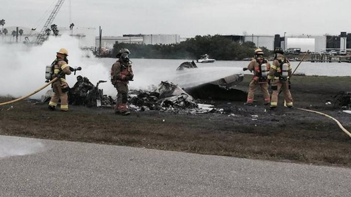 Los bombres tratan de apagar las llamas de la aeronave.