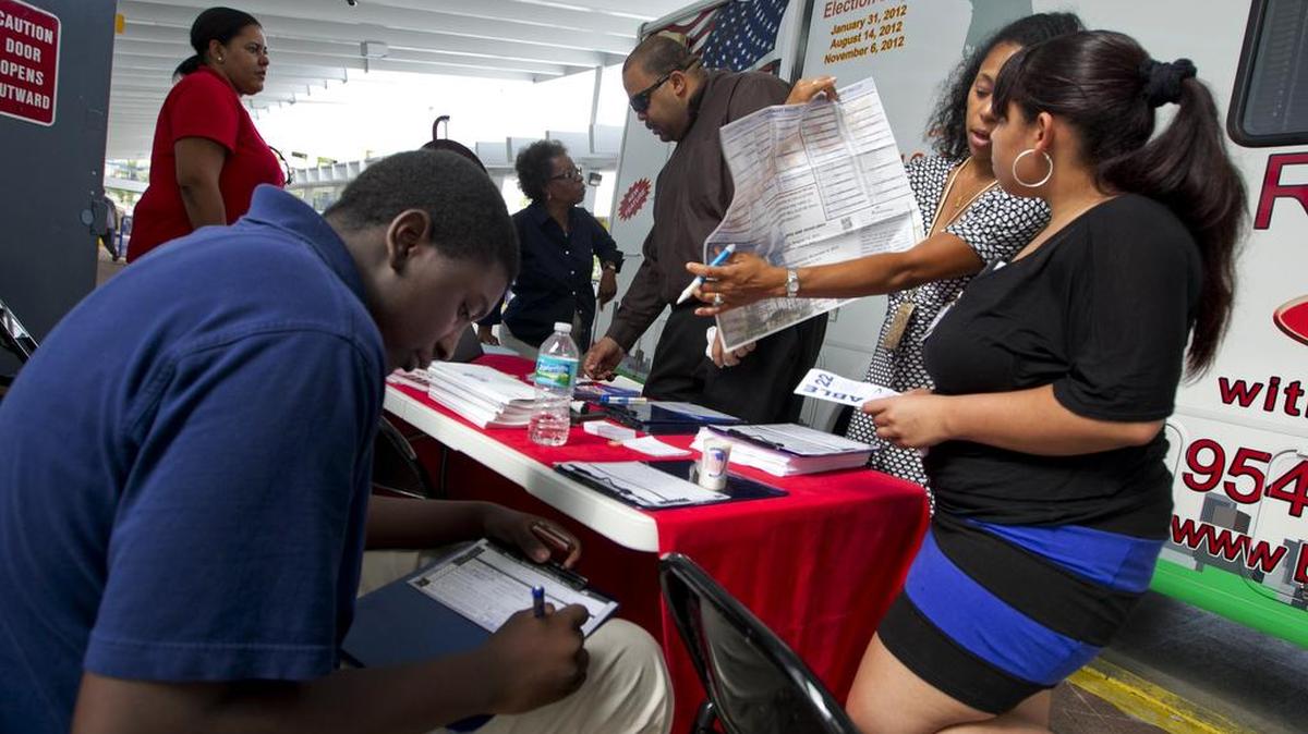 En esta imagen de archivo se aprecia a personal del Departamento de Elecciones de Broward inscribiendo nuevos votantes en la terminal de buses del downtown de Ft.Lauderdale en julio del 2012.