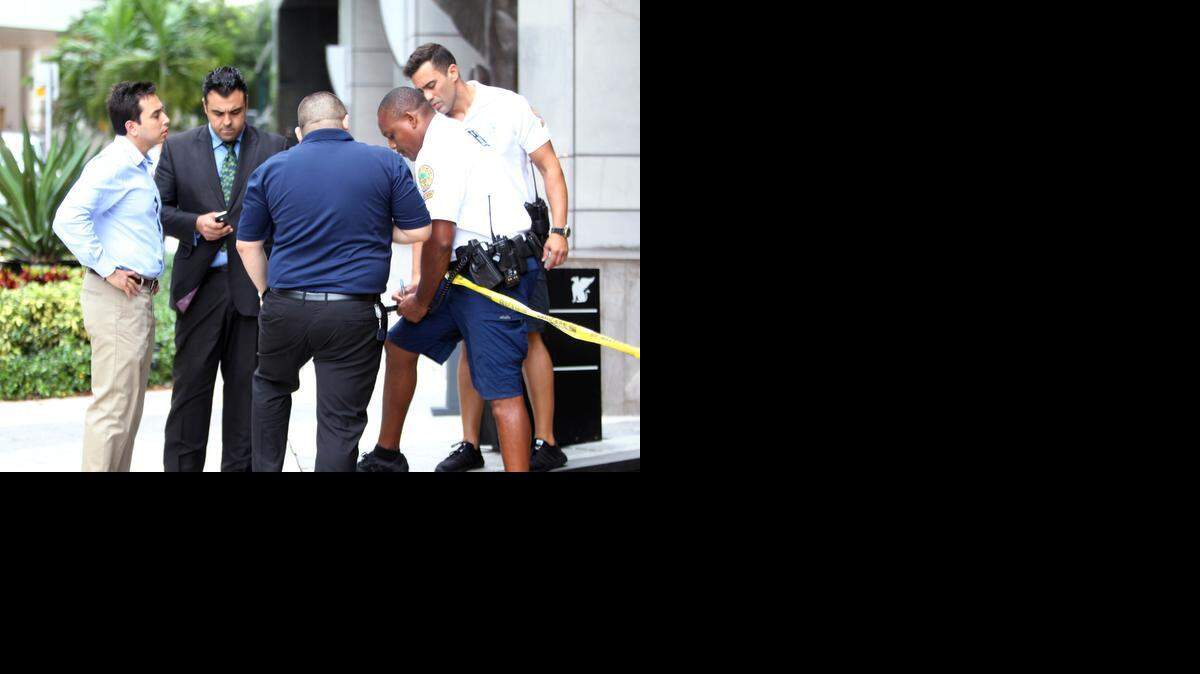 
Dos oficiales de la policia de la ciudad de Miami, hablan con algunos de los dueños de los vehiculos danados por un chofer que se dio a la fuga luego de chocar con 4 vehiculos y dejando varias personas lesionados en el Hotel Marriot del downtown de Miami el miercoles, 24 de septiembre del 2014. 
