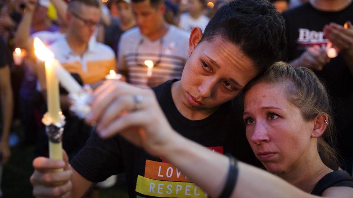 Foto del 13 de junio de 2016, Jennifer, a la derecha, y Mary Ware encienden velas durante una vigilia en el centro de la ciudad para las víctimas de un tiroteo en masa en el club nocturno Pulse en Orlando.