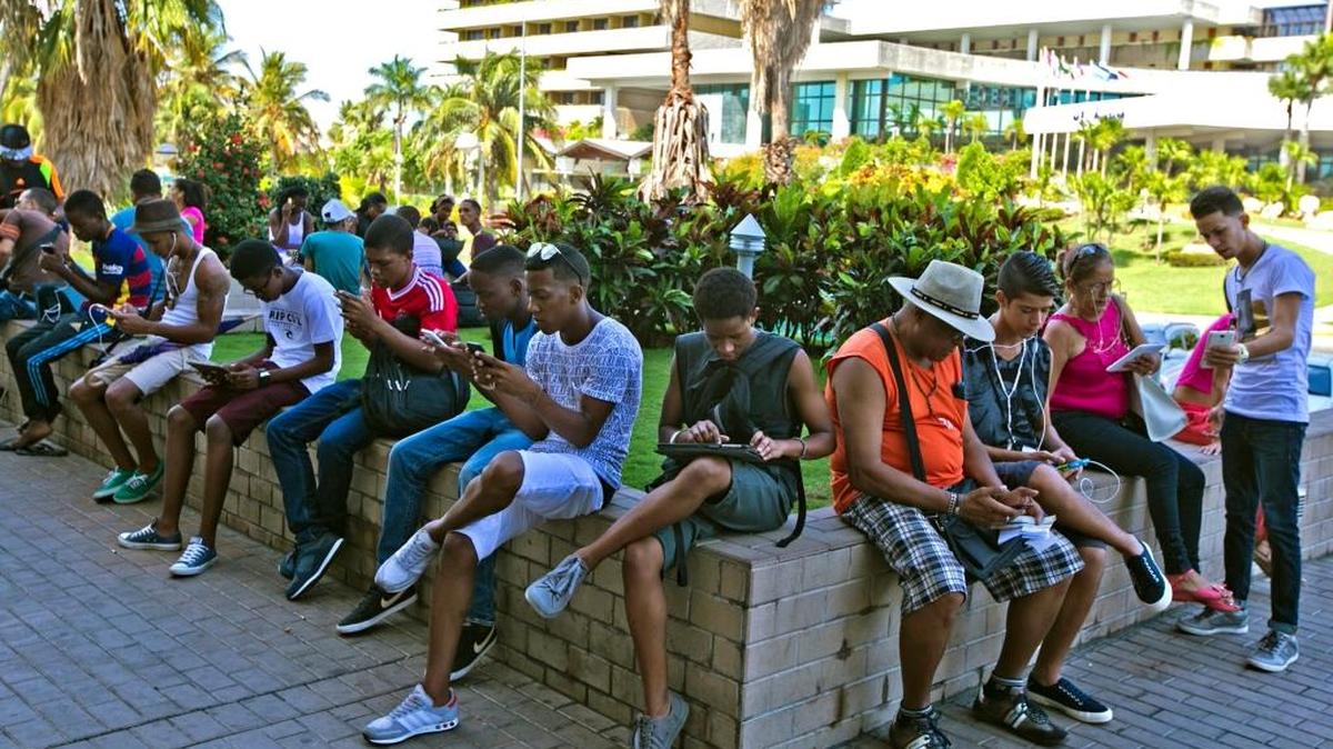 Cubanos se reúnen en un punto de acceso en Playa cerca de la oficina de ETECSA para recibir el servicio Wi-Fi el sábado 19 de septiembre, 2015, en La Habana, Cuba. La Reunión General Anual de la sección estadounidense de Amnistía Internacional (AIUSA) en Miami tocará, entre otros temas, las trabas para acceder a internet en Cuba y la tortura en el penal de Guantánamo.