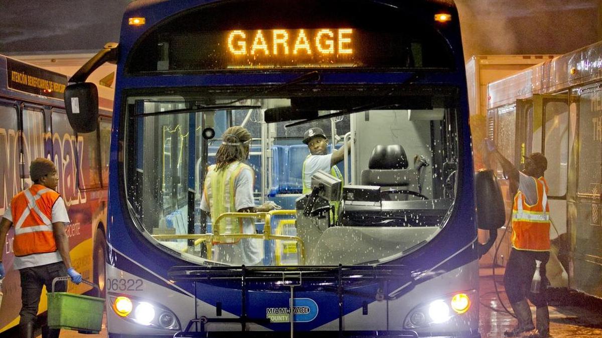 Una brigada de limpieza trabaja con uno de los ómnibus en el Rosa Parks Central Bus Transportation Building en septiembre.