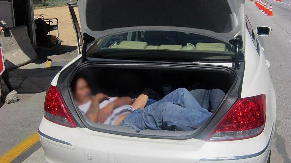 Dos inmigrantes indocumentados escondidos en el baúl de un auto en la frontera con México.