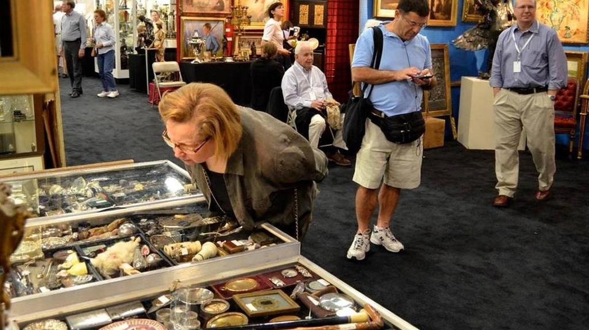 Betsy Balin admira lo que se exhibe en el puesto de Fred Heintz, en la edición del 2013 del Original Miami Beach Antique Show.