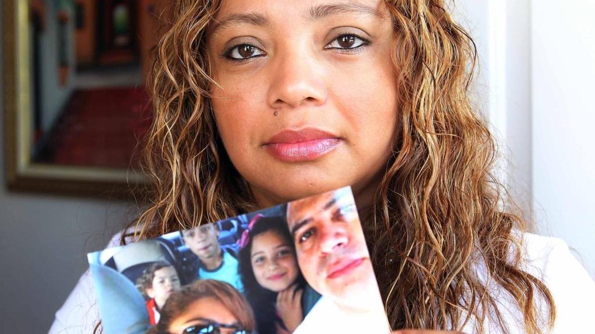 Karla Hernández sostiene una foto de su familia y su esposo, Mario Alcerro, quien fue deportado a Honduras el año pasado luego de haber regresado ilegalmente tras una deportación previa. La foto se tomó en el hogar de Hernández en junio del 2015.