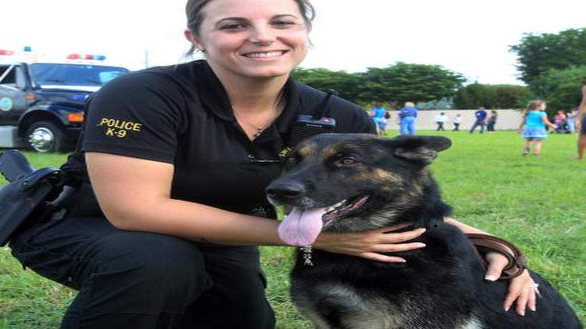 
La oficial de la Policía de Sweetwater Jenna Mendez junto a su perra Lana, en los terrenos de la escuela Sweetwater Elementary, el 9 de noviembre del 2013.
