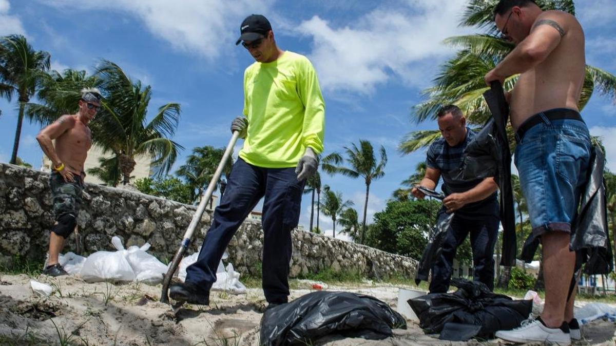 Vecinos se organizan y recogen arena para cubrir la entrada de sus hogares ante la proximidad del huracán Irma el viernes 8 de septiembre de 2017, en Miami (EE.UU.). Irma pasa entre Bahamas y la costa norte de Cuba en su camino hacia el estado de Florida luego de provocar al menos una docena de muertes y enormes daños materiales en el Caribe. El gobernador de Florida, Rick Scott, no ceja en insistir en que el huracán Irma es "catastrófico", el peor que el "estado nunca ha visto antes".
