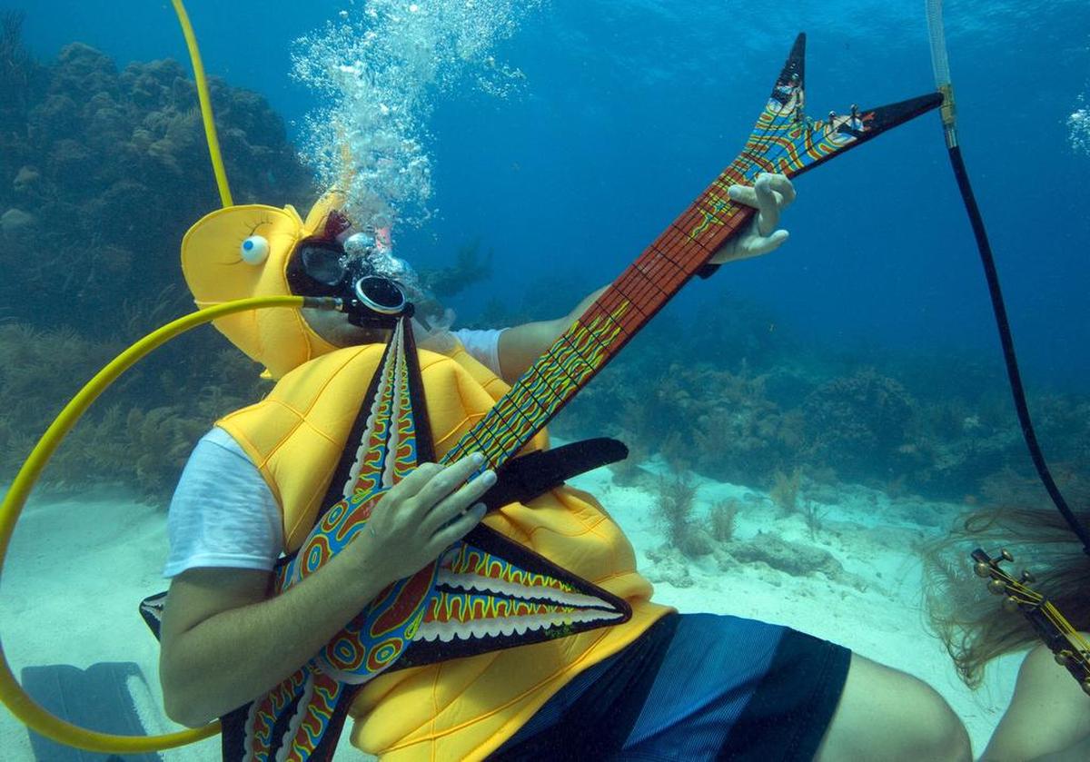 En una foto de la Oficina de Noticias de Florida Keys, Jeff Wright, vestido como un caballo de mar, toca una guitarra falsa, el sábado 11 de julio de 2015, en el Underwater Music Festival en el Santuario Marino Nacional de Florida Keys de Big Pine Key, Florida.