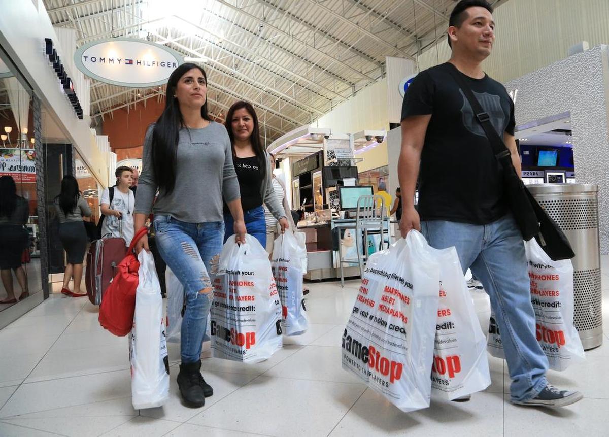 Cynthia Rivera, Angela Robles y Christian Valera de compras este jueves en el Dolphin Mall, que inició la temporada de ventas navideñas con un pasaporte de de descuentos.