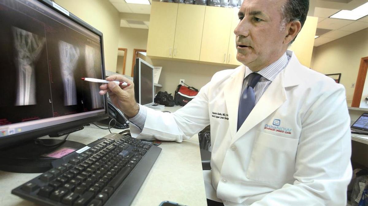 
El jefe médico de OrthoNOW es el cirujano ortopédico Alejandro Badía, M.D. En la imagen éste revisa unos rayos X de una fractura de muñeca en la clinica localizada en Doral.


