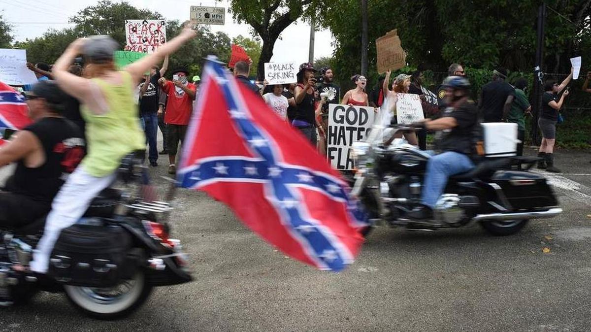 
Opiniones diferentes: Manifestantes a favor de la bandera confederada circulan en motocicleta frente a opositores, el domingo en Broward