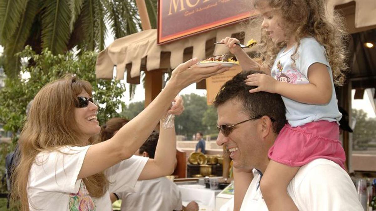 Una familia prueba los platillos internationales del Festival Internacional de Comida y Vino de Epcot, uno de los mas grandes de la nacion.