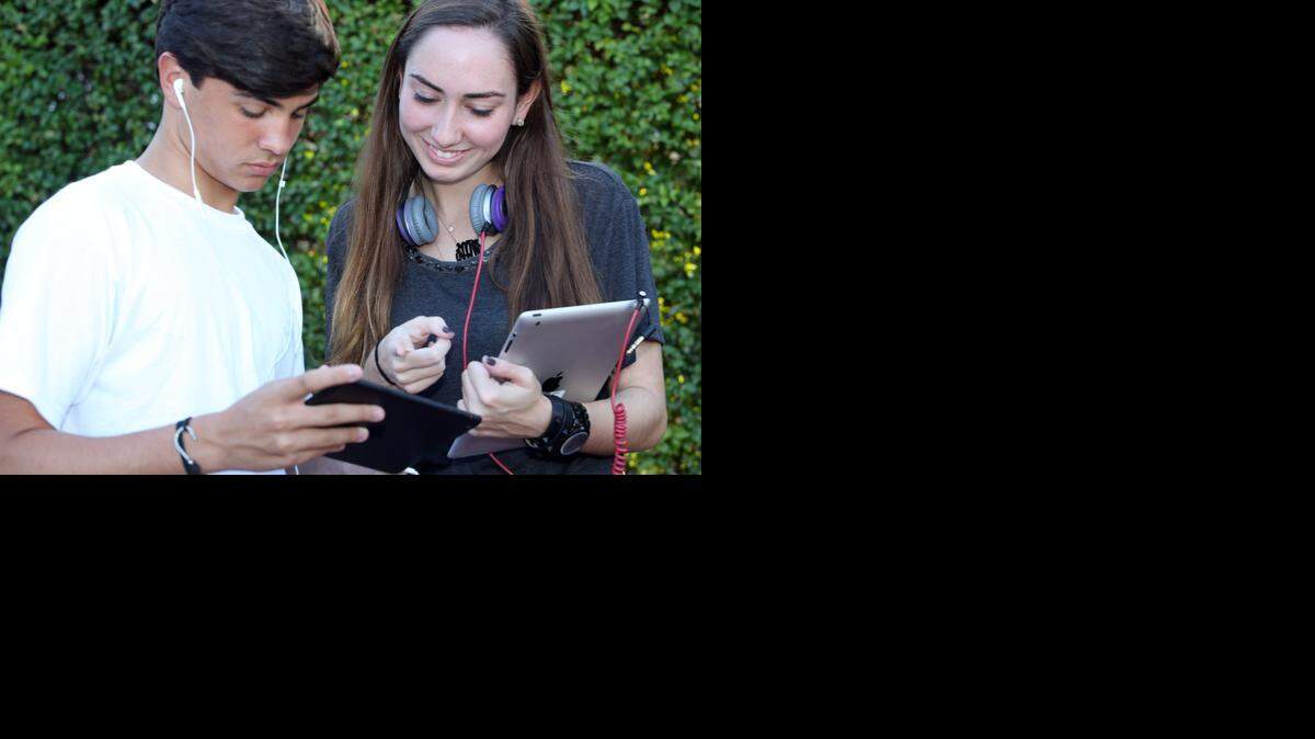 
Matthew Salas y Nicole Argüelles trabajan en sus Ipads el domingo. Los jóvenes en EEUU y otros países de América Latina y Europa usan más dispositivos digitales móviles que antes.


