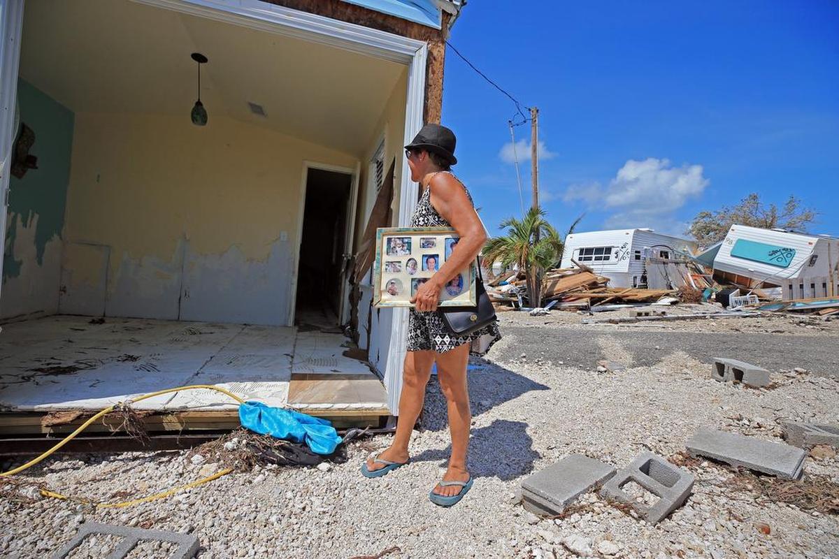 Laura Costello sostiene fotos familiares, lo único que se salvó en su casa móvil tras el paso del huracán Irma, el 12 de septiembre del 2017 en Islamorada.