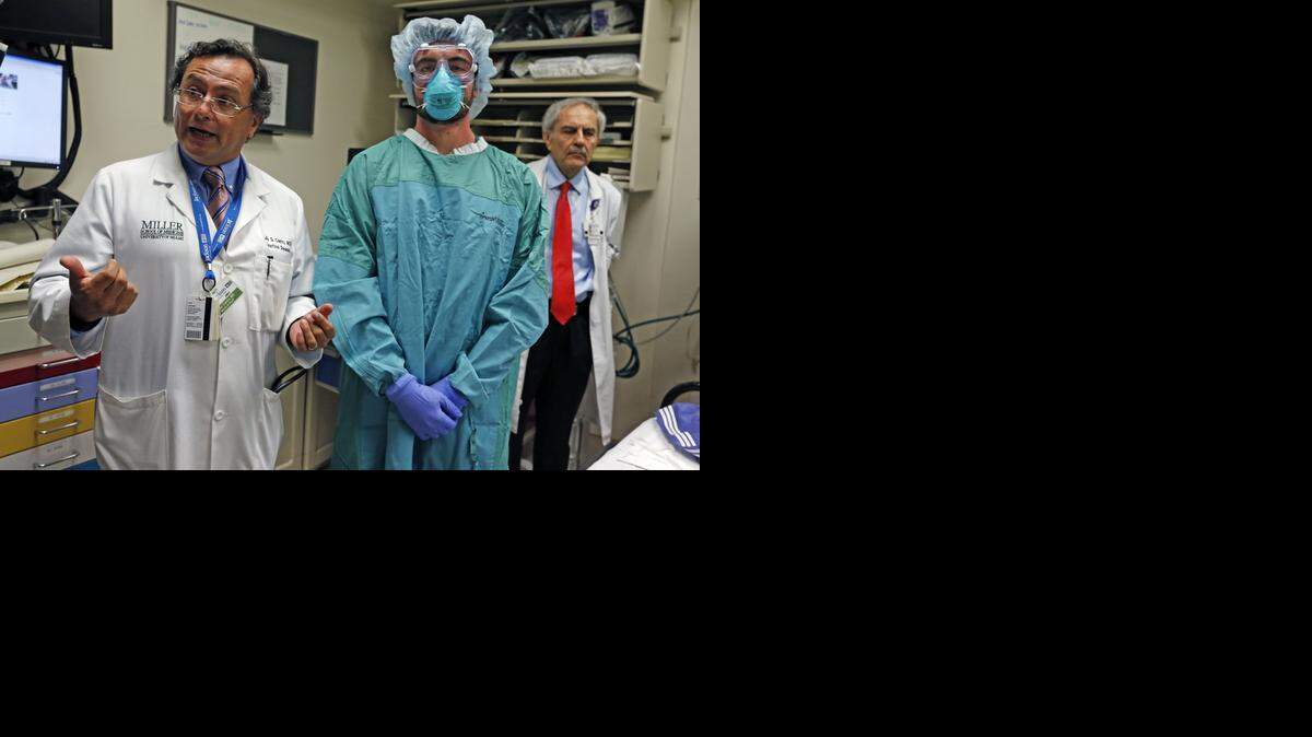 
Dr. Jose G. Castro, médico especializado en enfermedades infecciosas, describe el traje protector que usa el estudiante Christopher Dermarkarian. 



