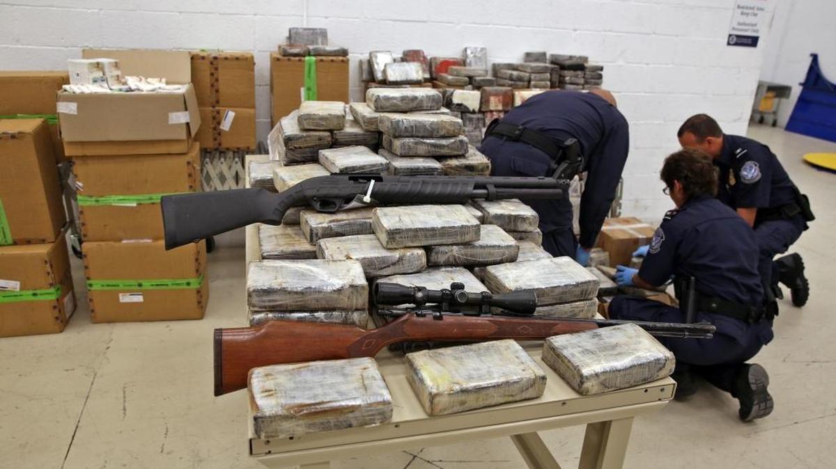 En esta foto de archivo se ven funcionarios de la oficina de Aduanas y Protección Fronteriza revisando evidencia, incluso armas, en una instalación en el Condado Miami-Dade.