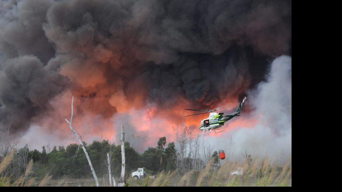 Los equipos de emergencia trabajan en el lugar de un gran incendio forestal en el suroeste de Miami-Dade el domingo, 19 de abril de 2015.
