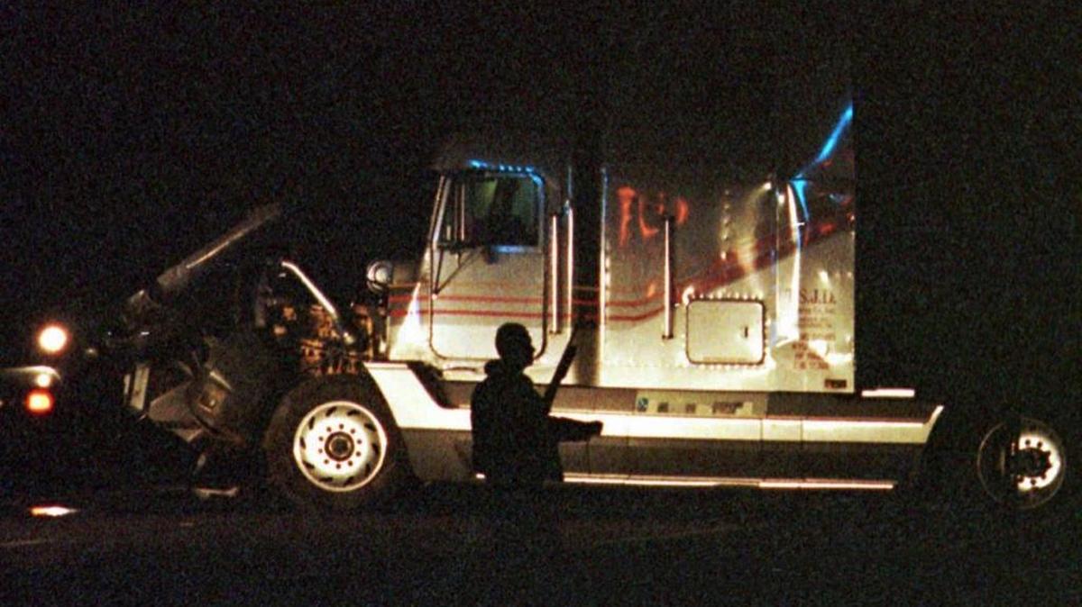 Un agente de la policía carga una escopeta frente a un camión de carga robado cerca de la autopista I-77, en el Condado Chester de Carolina del Sur el 13 de diciembre de 1997.