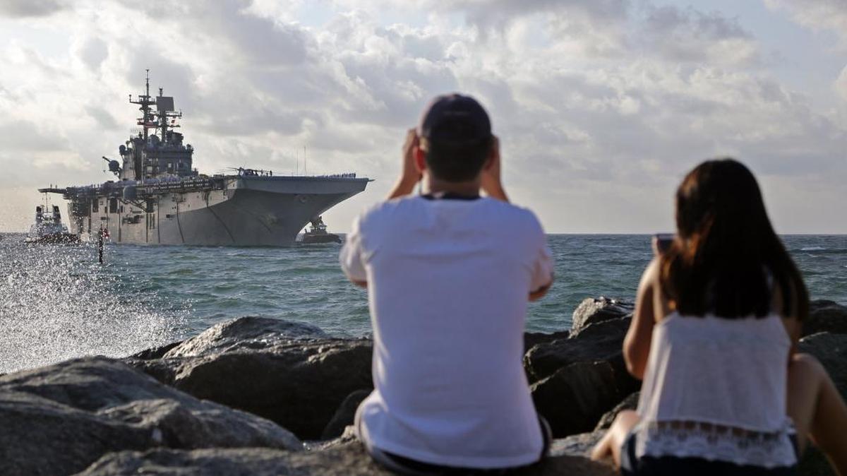 Brandon Frantz, de 18 años, y Shirley Chua, de 19 años, ambos residentes de Pembroke Pines, observan la llegada del buque USS Bataan al Puerto Everglades, el 2 de mayo en Fort Lauderdale.