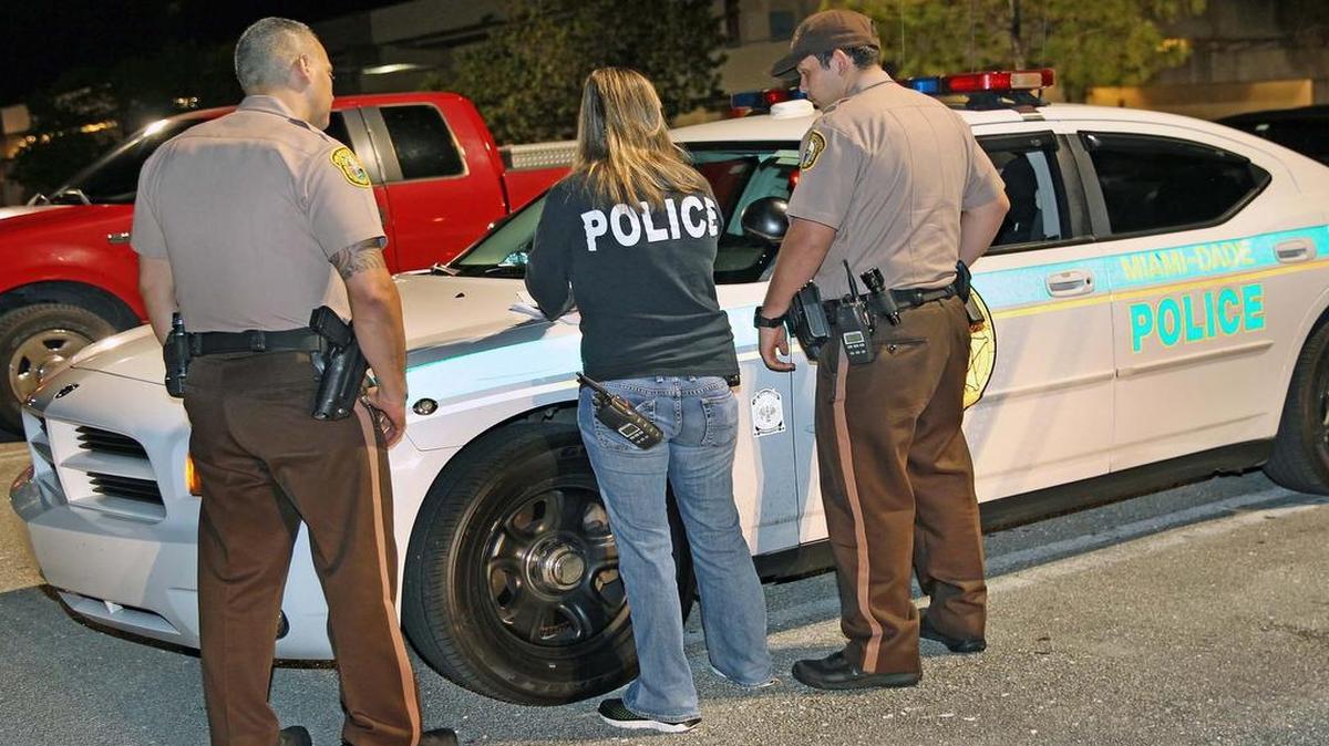 Agentes de la policía de Miami-Dade coordinan con un oficial encubierto antes de realizar el primer arresto por fraude en condominios en septiembre del 2016, tras una serie de investigación de el Nuevo Herald y Univisión 23.